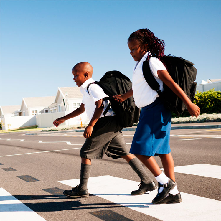 two children cross sidewalk